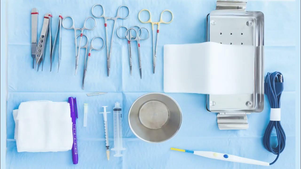A set of medical tools arranged on a sterile blue surface.